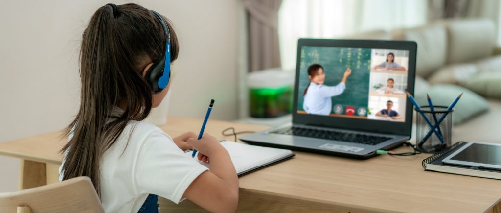 Asian girl student video conference e-learning with teacher and classmates on computer in living room at home. Homeschooling and distance learning ,online ,education and internet.